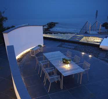 Spisebord på oval terrasse i skifer designet af havearkitekt Tor Haddeland